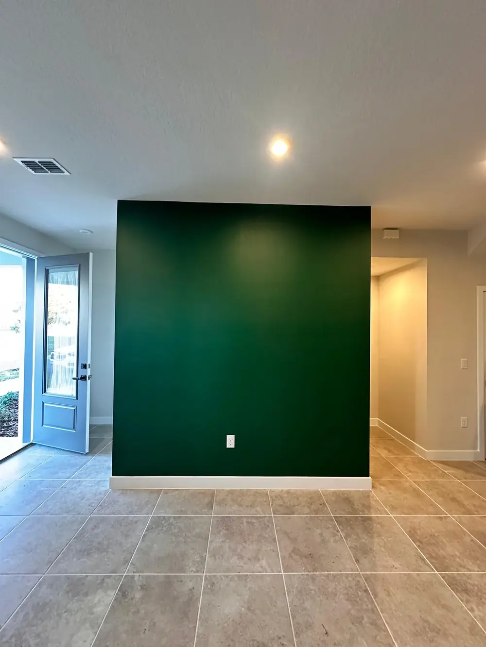 Deep green accent wall with refinished trim